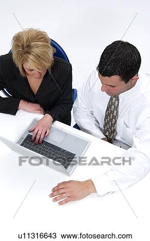 Stock Image - Man and woman working on laptop computer. Fotosearch