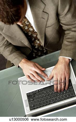 Top view of businessman working on laptop computer View Large Photo Image Stock Photograph - Top view of businessman working on laptop computer. Fotosearch
