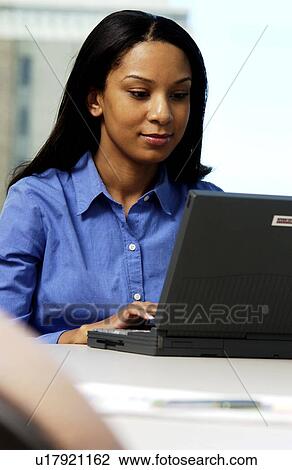 Stock Image - Woman working on laptop. Fotosearch