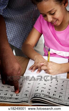 Stock Image - African American father helping daughter with homework. Fotosearch