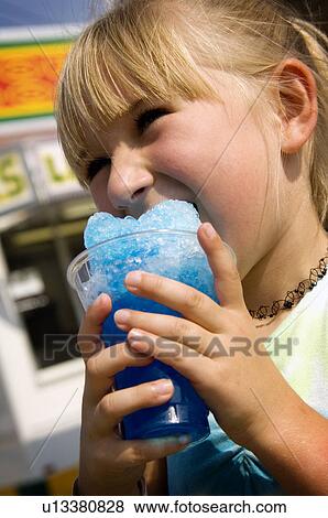 Stock Photo - Girl eating carnival food. Fotosearch