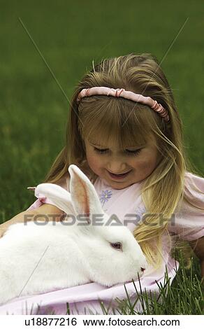 Girl holding white bunny View Large Photo Image Stock Photograph - Girl holding white bunny. Fotosearch