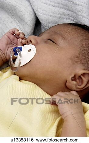 Stock Photograph - Newborn sleeping with pacifier. Fotosearch