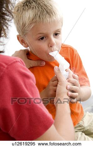 Stock Photography - Woman helping boy with breathing machine. Fotosearch