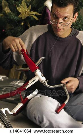 Dad assembling tricycle View Large Photo Image Picture - Dad assembling tricycle. Fotosearch