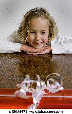 Girl waiting to open gift View Large Photo Image Stock Photo - Girl waiting to open gift. Fotosearch