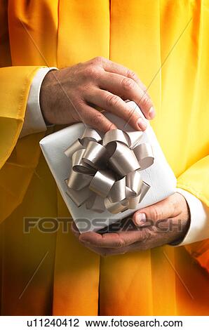Graduate holding a gift View Large Photo Image Stock Image - Graduate holding a gift. Fotosearch