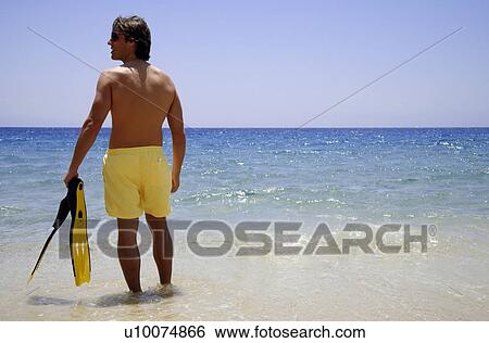 Man in water with flippers on the beach View Large Photo Image Stock Photograph - Man in water with flippers on the beach. Fotosearch