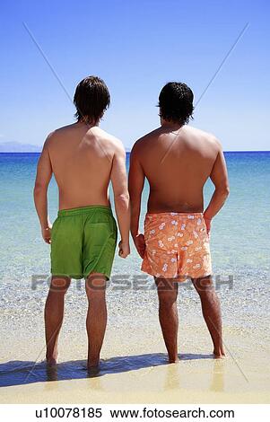 Two men on the beach looking out to sea View Large Photo Image Stock Photography - Two men on the beach looking out to sea. Fotosearch