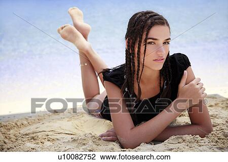 Young woman lying on beach View Large Photo Image Stock Image - Young woman lying on beach. Fotosearch
