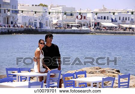 Couple by seaside restaurant tables View Large Photo Image Stock Image - Couple by seaside restaurant tables. Fotosearch