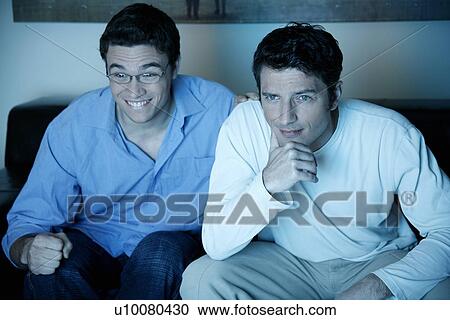 Stock Image - Two men watching a game on television. Fotosearch
