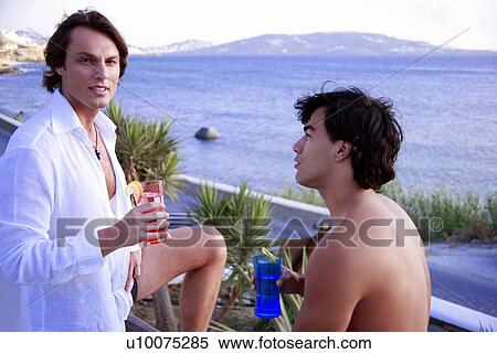 Two men with cocktails by the seaside View Large Photo Image Stock Photography - Two men with cocktails by the seaside. Fotosearch