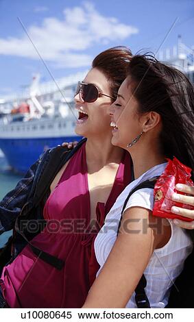 Stock Photography - Two young women in front of ferry laughing. Fotosearch