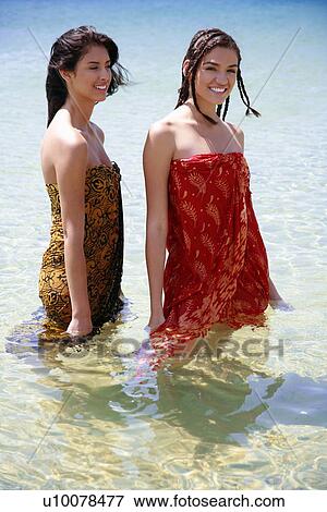 Two young women posing in water View Large Photo Image Stock Photo - Two young women posing in water. Fotosearch