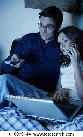 Young couple watching television View Large Photo Image Picture - Young couple watching television. Fotosearch