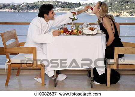 Stock Photo - Couple having breakfast on hotel terrace. Fotosearch