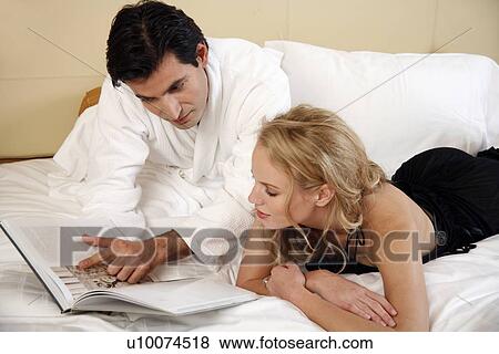 Couple relaxing in bed View Large Photo Image Stock Photo - Couple relaxing in bed. Fotosearch