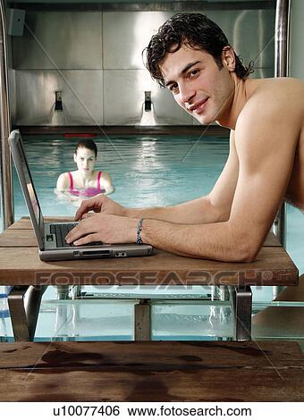 Man on computer next to a swimming pool View Large Photo Image Stock Photograph - Man on computer next to a swimming pool. Fotosearch