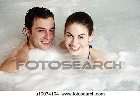 Picture - One man with one woman in jacuzzi at a spa. Fotosearch