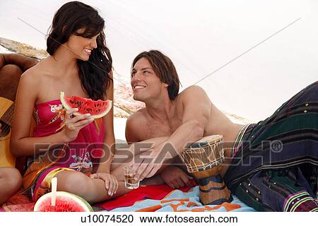 Young couple sitting on beach View Large Photo Image Stock Image - Young couple sitting on beach. Fotosearch