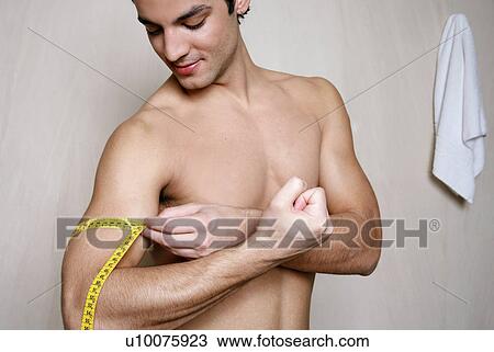 Man measuring his arm muscle View Large Photo Image Stock Image - Man measuring his arm muscle. Fotosearch