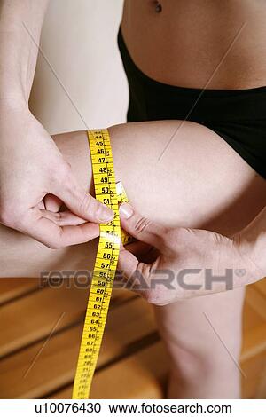 Stock Image - Man measuring his thigh. Fotosearch
