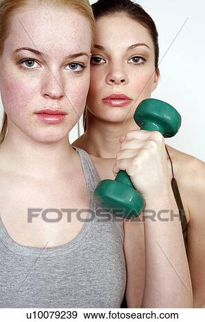 Stock Photo - Two young women with dumbbell. Fotosearch