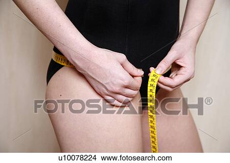 Woman measuring her hips View Large Photo Image Picture - Woman measuring her hips. Fotosearch