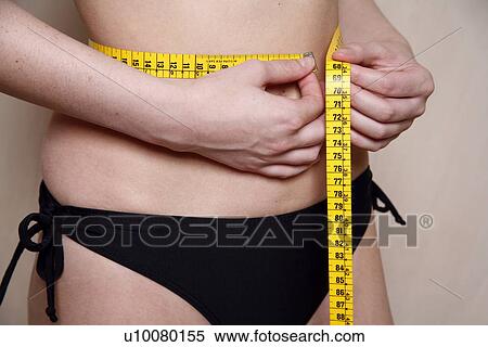 Stock Photography - Woman measuring her waist. Fotosearch