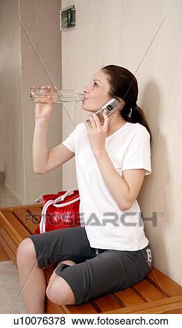 Stock Photo - Woman relaxing in locker room after the gym. Fotosearch