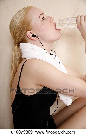 Stock Photo - Woman relaxing in locker room after the gym. Fotosearch