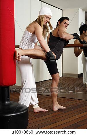 Young man and woman practicing with a punching bag View Large Photo Image Stock Image - Young man and woman practicing with a punching bag. Fotosearch