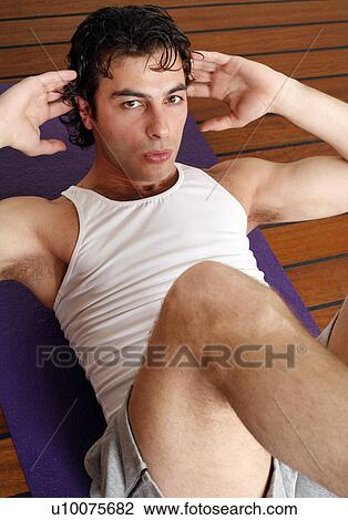 Stock Image - Young man doing situps. Fotosearch