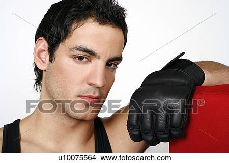 Young man leaning on punching bag View Large Photo Image Picture - Young man leaning on punching bag. Fotosearch