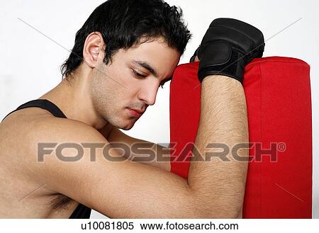 Young man leaning on punching bag View Large Photo Image Stock Photography - Young man leaning on punching bag. Fotosearch