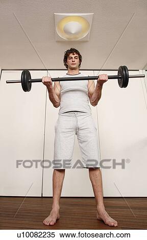 Young man lifting weights View Large Photo Image Stock Photography - Young man lifting weights. Fotosearch