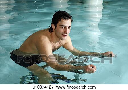 Young man on exercise bike in spa pool View Large Photo Image Stock Photo - Young man on exercise bike in spa pool. Fotosearch