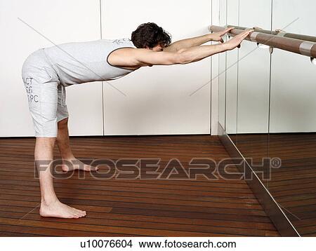 Young man stretching in gym View Large Photo Image Picture - Young man stretching in gym. Fotosearch