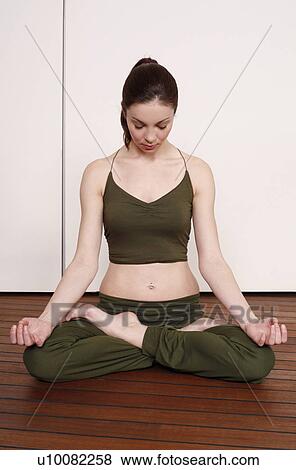 Stock Photo - Young woman in a fitness class meditating. Fotosearch