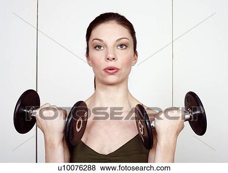 Young woman lifting weights View Large Photo Image Stock Photo - Young woman lifting weights. Fotosearch