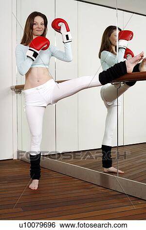 Stock Photograph - Young woman practicing Capoeira move. Fotosearch