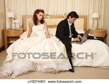 Stock Image - Bride waiting for groom to get off his laptop. Fotosearch