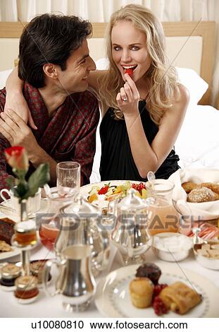 Couple having room service breakfast in hotel room View Large Photo Image Stock Image - Couple having room service breakfast in hotel room. Fotosearch