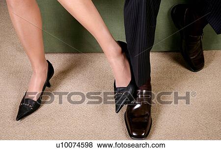 Stock Photo - Man and Woman playing footsie. Fotosearch