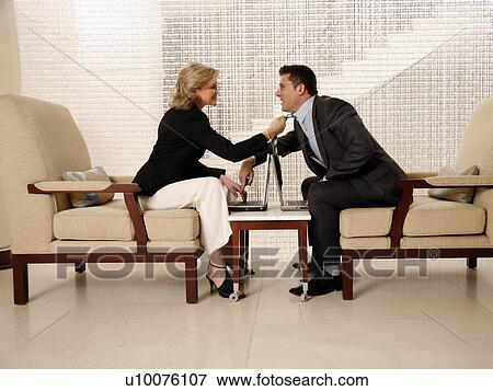 Stock Photo - Man and woman sitting in hotel lobby. Fotosearch