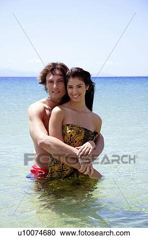 Man embracing woman in the water View Large Photo Image Stock Image - Man embracing woman in the water. Fotosearch