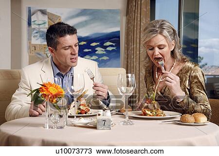 Stock Image - Mature couple dining in a restaurant. Fotosearch