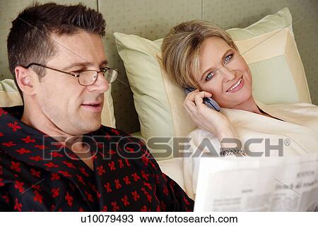 Stock Image - Mature couple relaxing in bed. Fotosearch