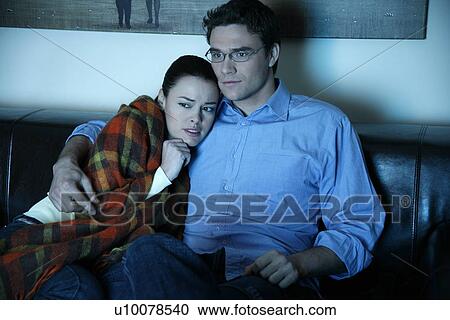 Stock Image - Young couple watching television. Fotosearch